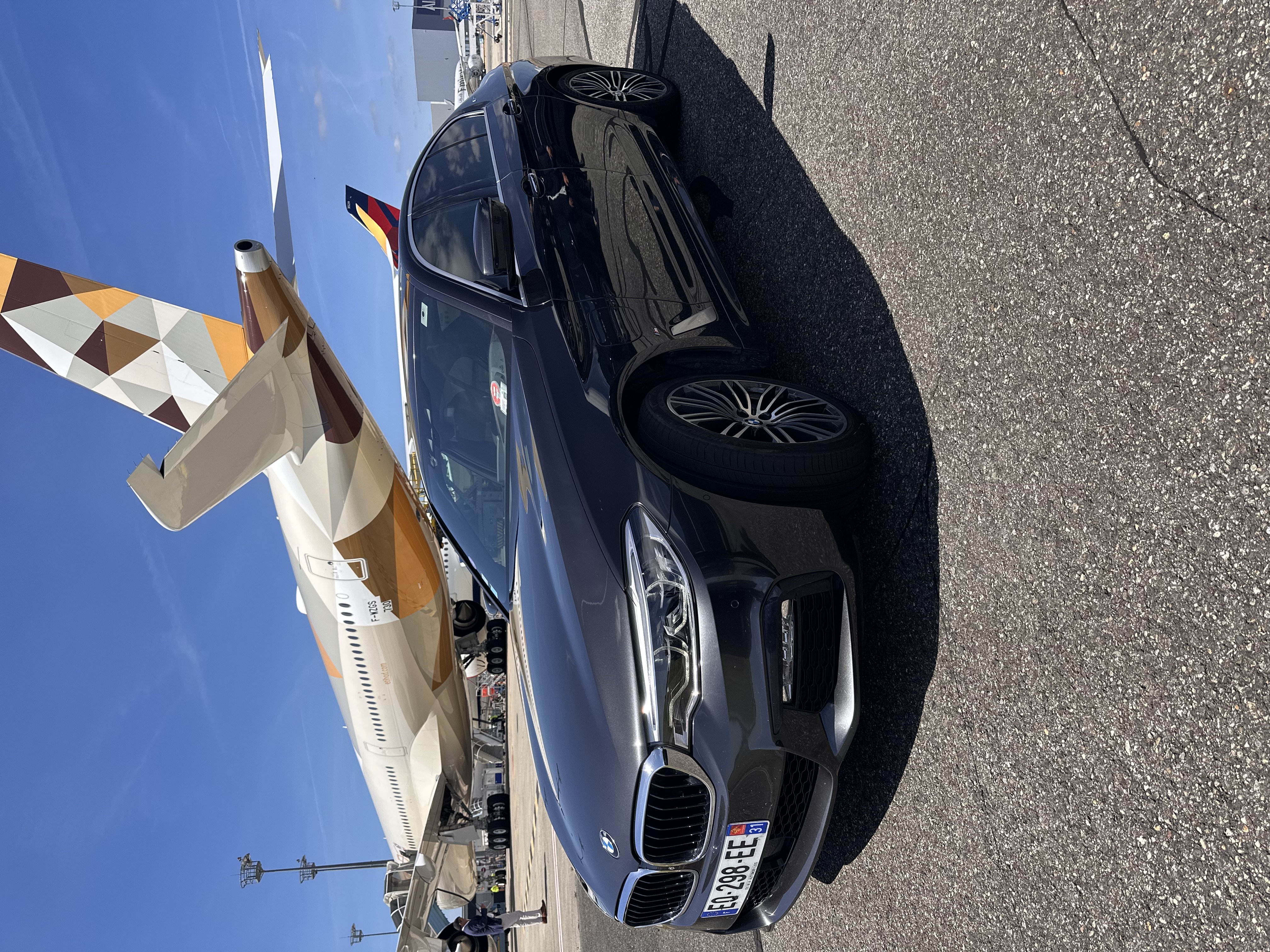 Berline DRIVINE devant un avion à l'aéroport